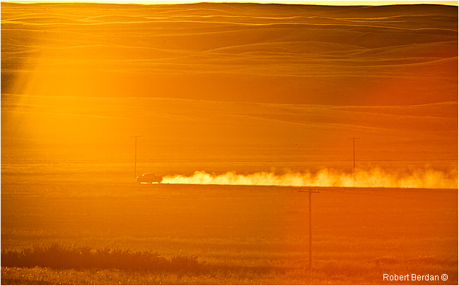 Truck kicks kup dust on the prairie at sunset by Robert Berdan ©
