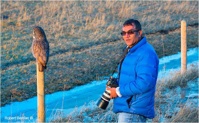 Kamal Varma standing next to a Great Gray Owl by Robert Berdan ©