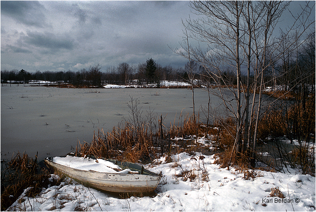 Old wooden boat on shoreline in snow by Karl Berdan ©